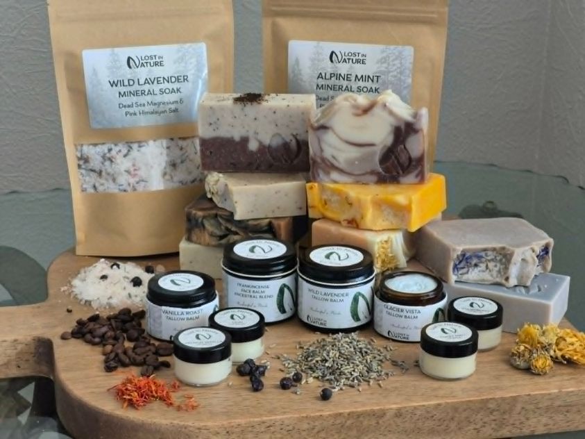 Lost in Nature soaps, tallow balms, and mineral soaks displayed on a wooden board