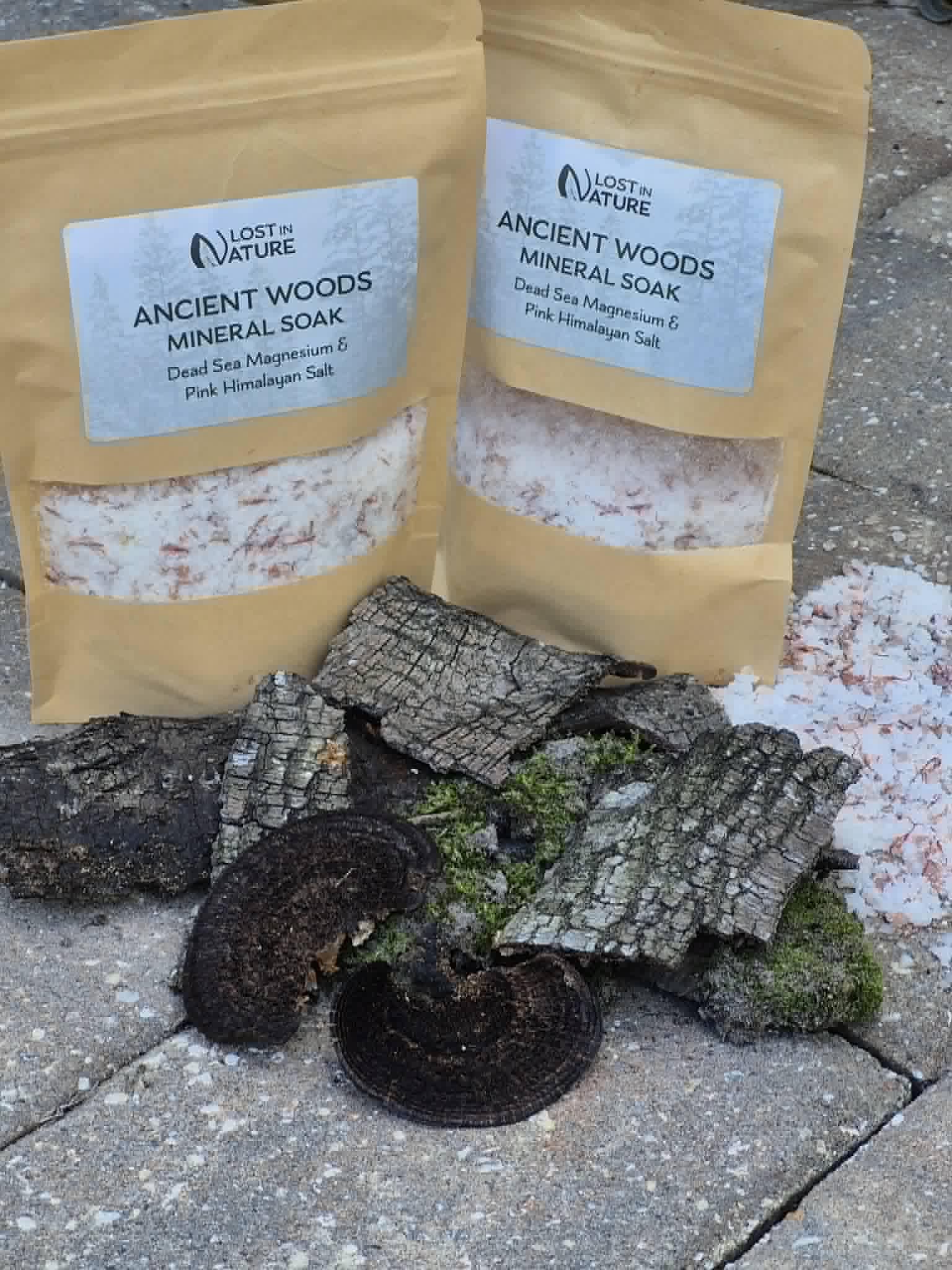 Ancient Woods mineral soak photographed with charcoal and moss
