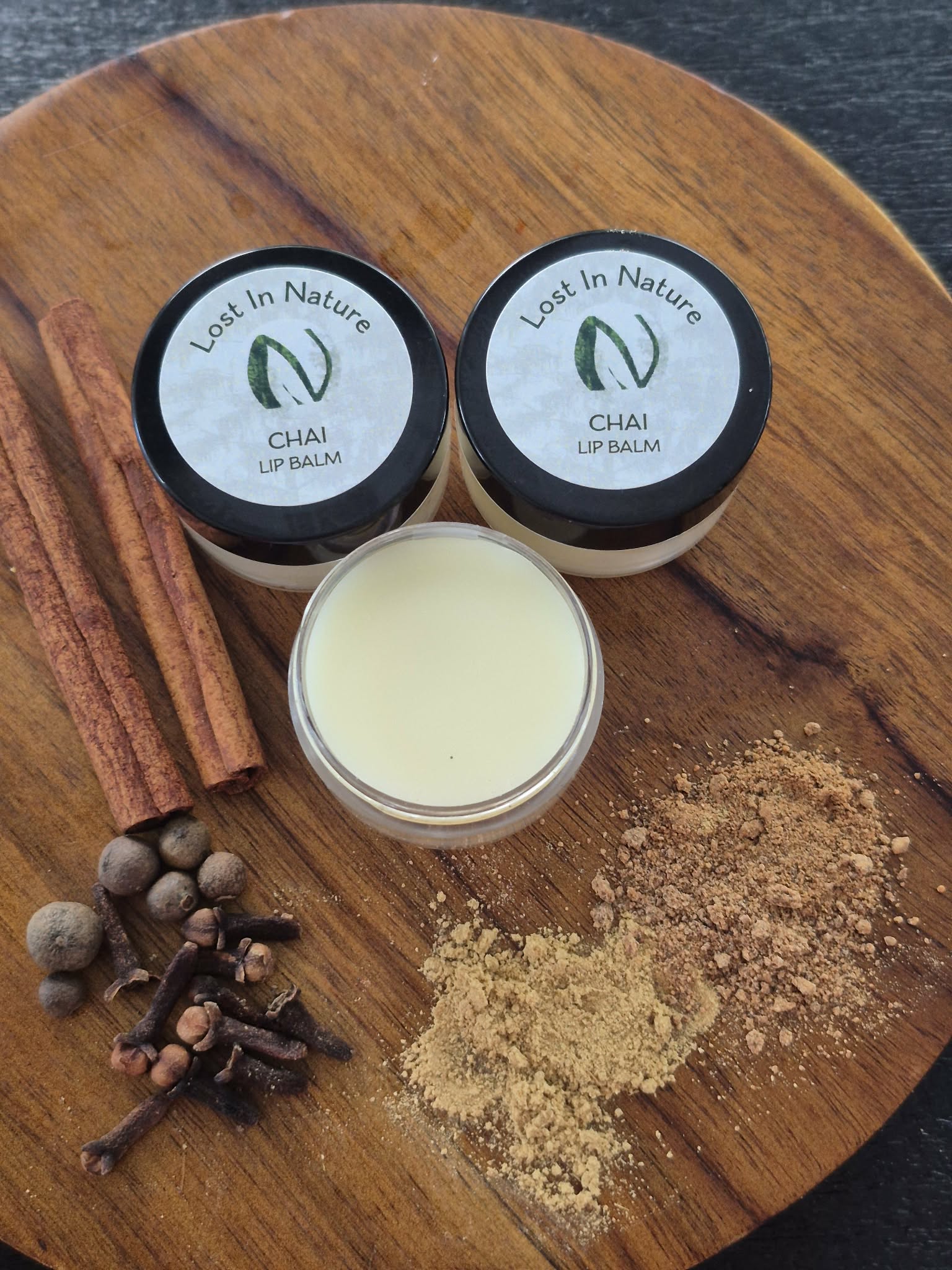 Chai lip balm arranged with cinnamon and warming spices